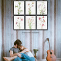 Six wildflower prints above a couple and guitar on a wood wall