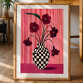 Framed pink floral checkered vase wall art displayed on a living room floor