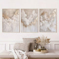 Neutral cloud canvas set in white frames above a wooden bench