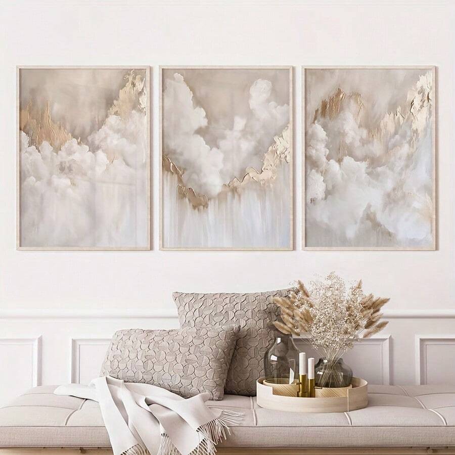 Neutral cloud canvas set in white frames above a wooden bench
