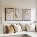 Cloud triptych wall art in black frames above a modern sofa