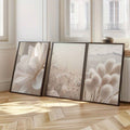 Neutral botanical triptych leaning in dark frames on the floor