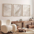 Textured beige abstract three-piece canvas set above a console