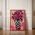 Pop-surreal floral vase poster with pink eyes in a warm wood frame