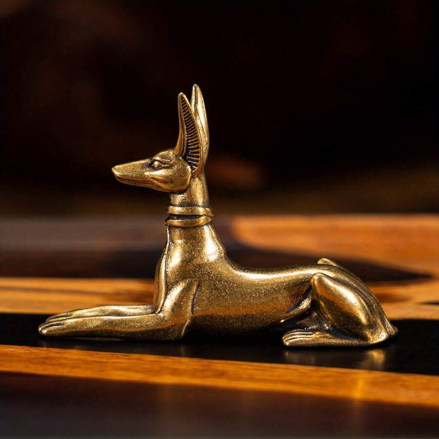 Vintage brass Egyptian jackal statue in lying sphinx pose.