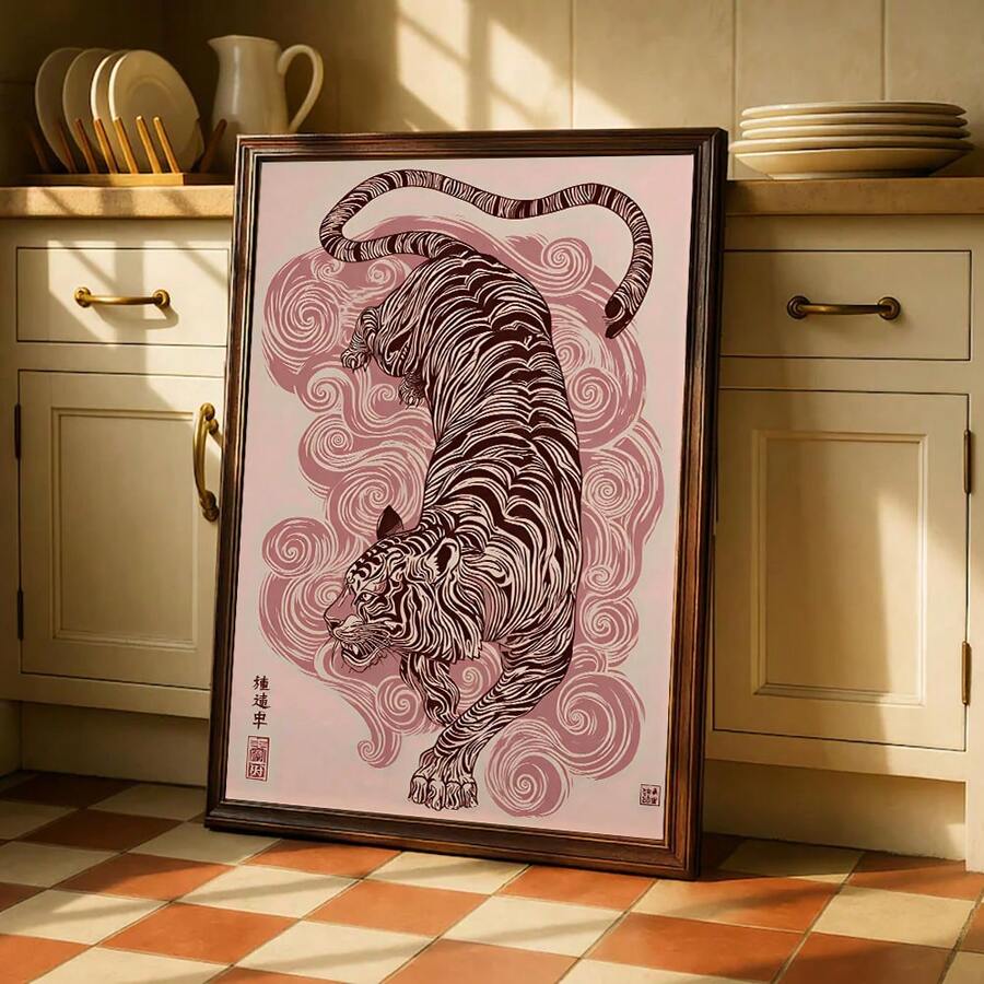 Pink tiger and cloud swirl poster in a dark frame near kitchen cabinets