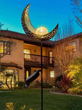 Solar moon stake light glowing in garden with warm crackle glass globe.