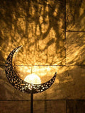 Waterproof crescent moon solar light with black stake and patterned wall shadow.