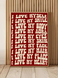 Close view of red self love affirmation poster leaning against wood slat wall