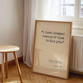 Framed gothic romance quote poster leaning below window near radiator