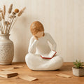Size graphic showing reading girl ornament about 8.5 cm high and 6.6 cm wide.
