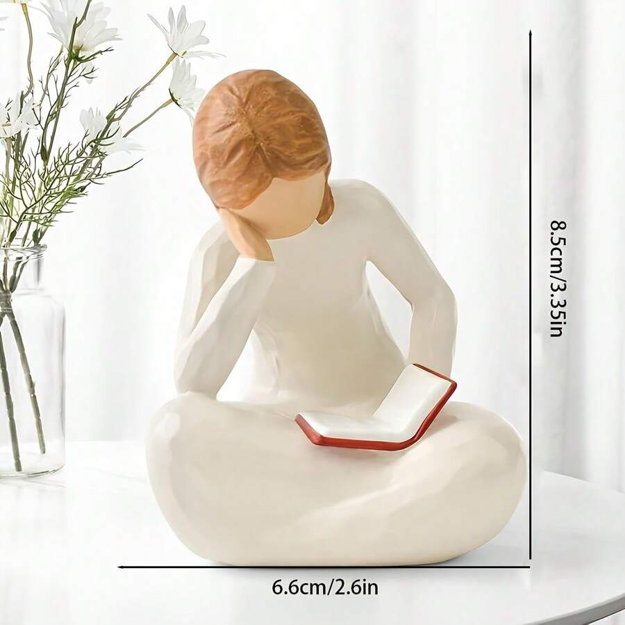 Resin reading girl figurine sitting cross-legged with open book.