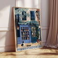 Large framed bookstore dog poster leaning on floor beside curtains in soft light