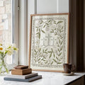 Framed botanical cross artwork styled on a marble console with flowers