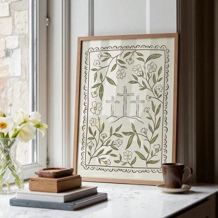 Framed botanical cross artwork styled on a marble console with flowers