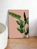 Oversized pink tropical leaf poster leaning beside a white chair