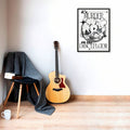 Framed black and white disco ball poster on wall beside acoustic guitar and chair