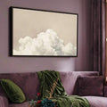 Minimalist poster in black frame above sofa on mauve wall with soft cloud painting