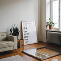 Good day motivational poster leaning near sofa and window in modern room