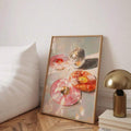 Framed portrait donut and disco ball painting leaning beside a white bed and brass lamp
