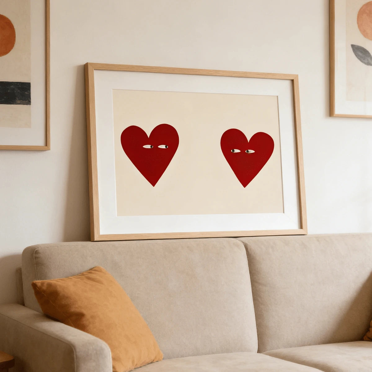 Framed red heart couple artwork above a beige sofa