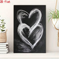 Black canvas with overlapping white chalk hearts beside books and plants