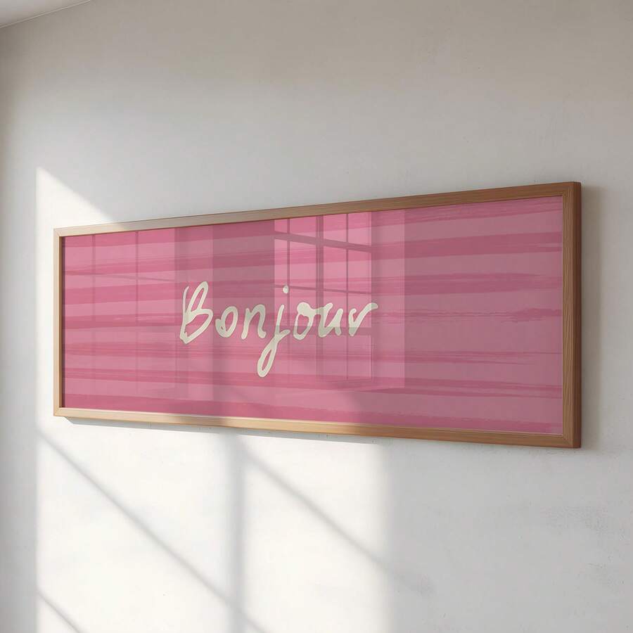 Pink framed Bonjour wall art with cream script lettering on striped blush background
