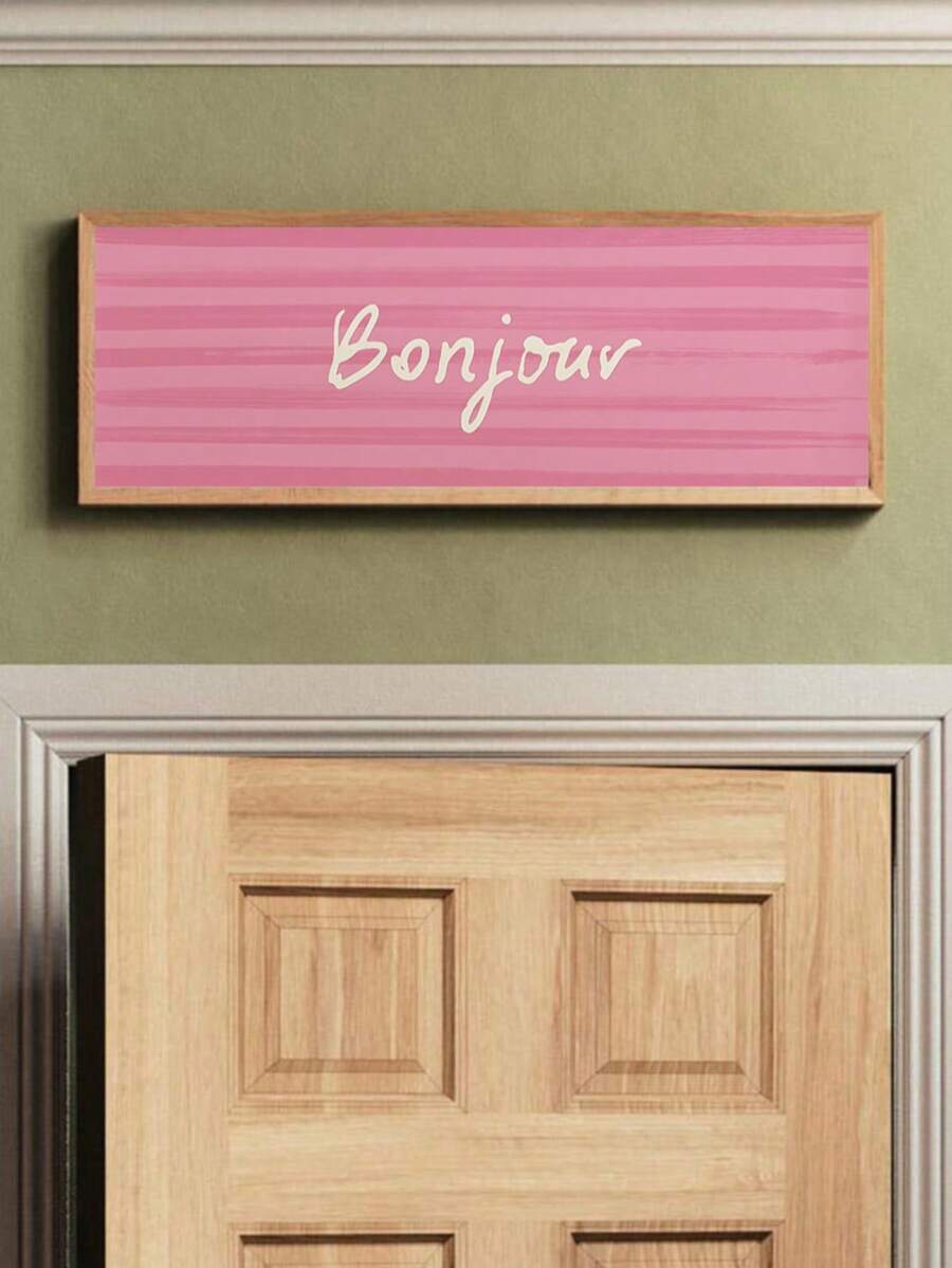 Pink framed Bonjour wall art with cream script lettering on striped blush background