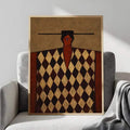 Geometric figure portrait wall art in natural wood frame on gray armchair