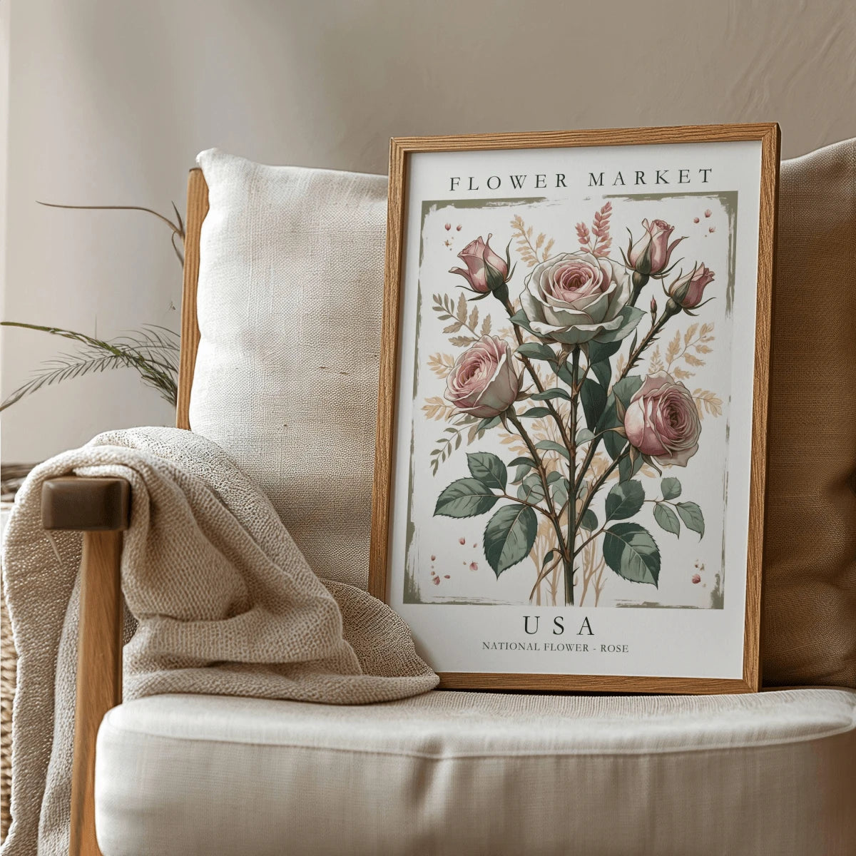 Pink rose botanical poster leaning on a pale upholstered chair