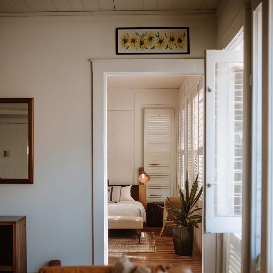 Small black framed sunflower print above bedroom doorway