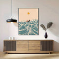 Black-framed surfing girl ocean wave poster displayed above a wooden sideboard
