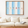 Framed summer surfer print above a white sofa with natural wood accents