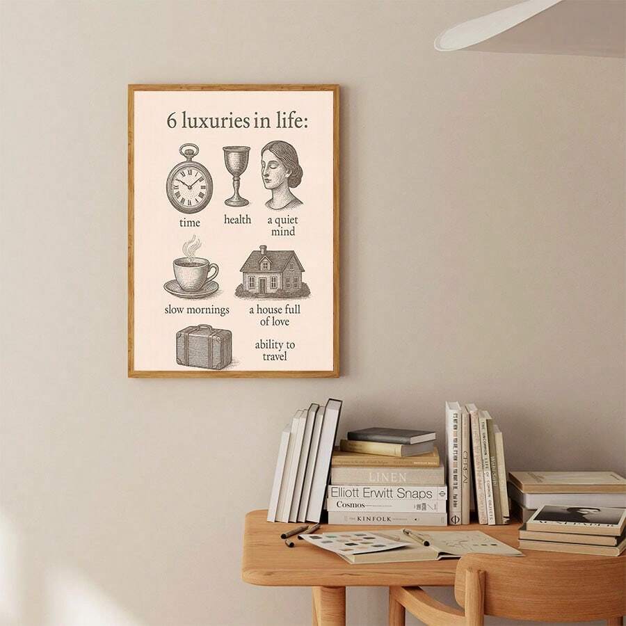 Vintage inspirational text artwork in a wood frame above a minimalist desk with books and sketches