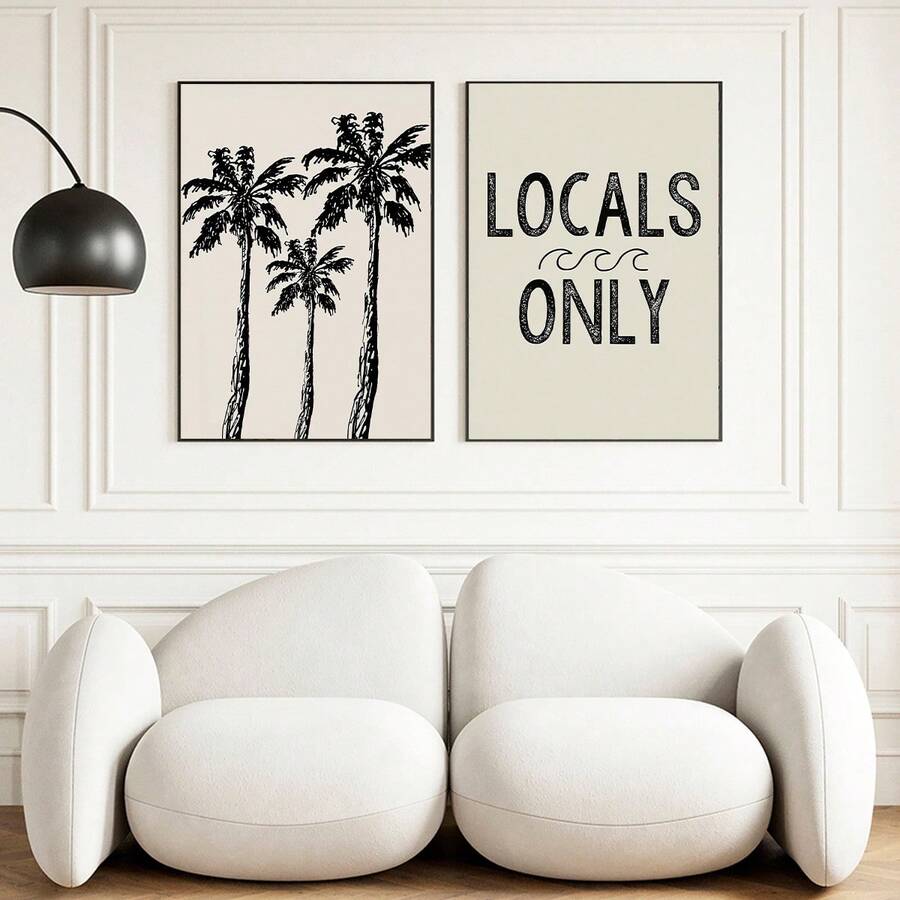 Pair of palm and coastal typography prints above pale lounge chairs