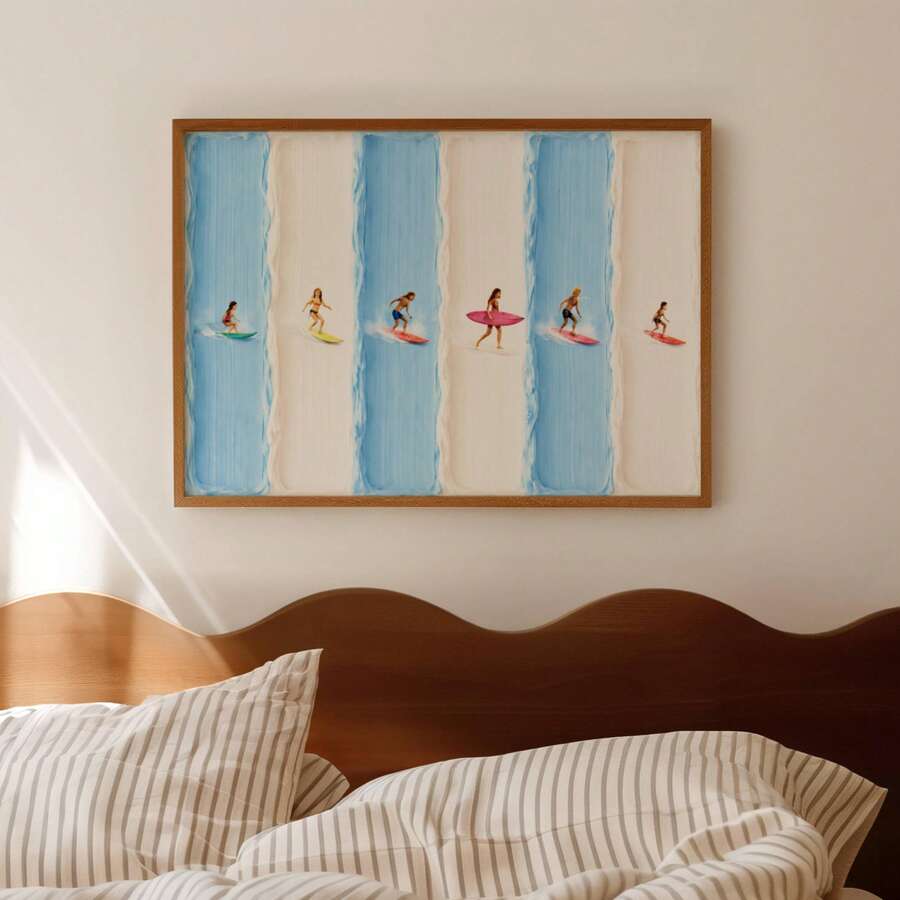 Framed surfer illustration above a bed with striped bedding and wood headboard
