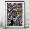 Black-framed retro optical art displayed against a pale wall with modern accessories