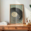 Framed retro record-player poster displayed above a warm wooden console