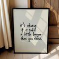Black framed inspirational quote poster beside curtains and wood paneling