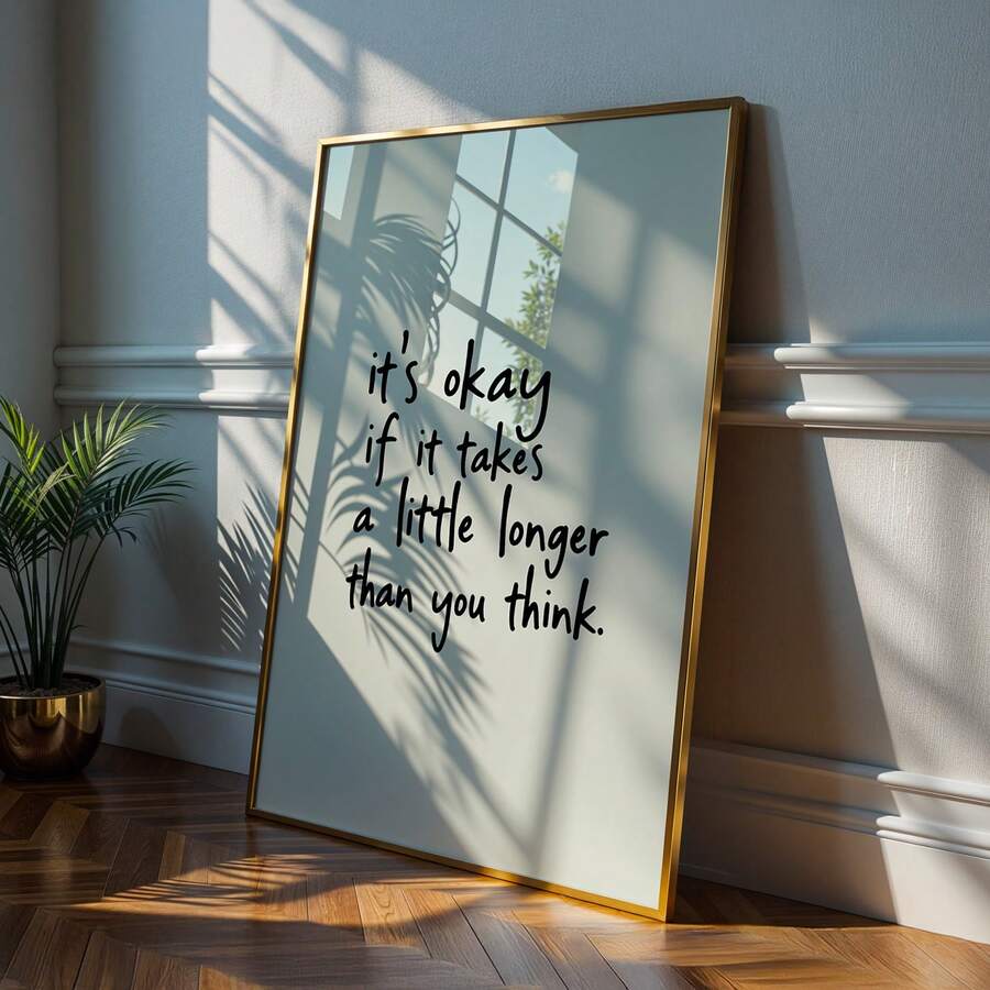 Gold framed motivational quote poster with sunlight and indoor plant shadows