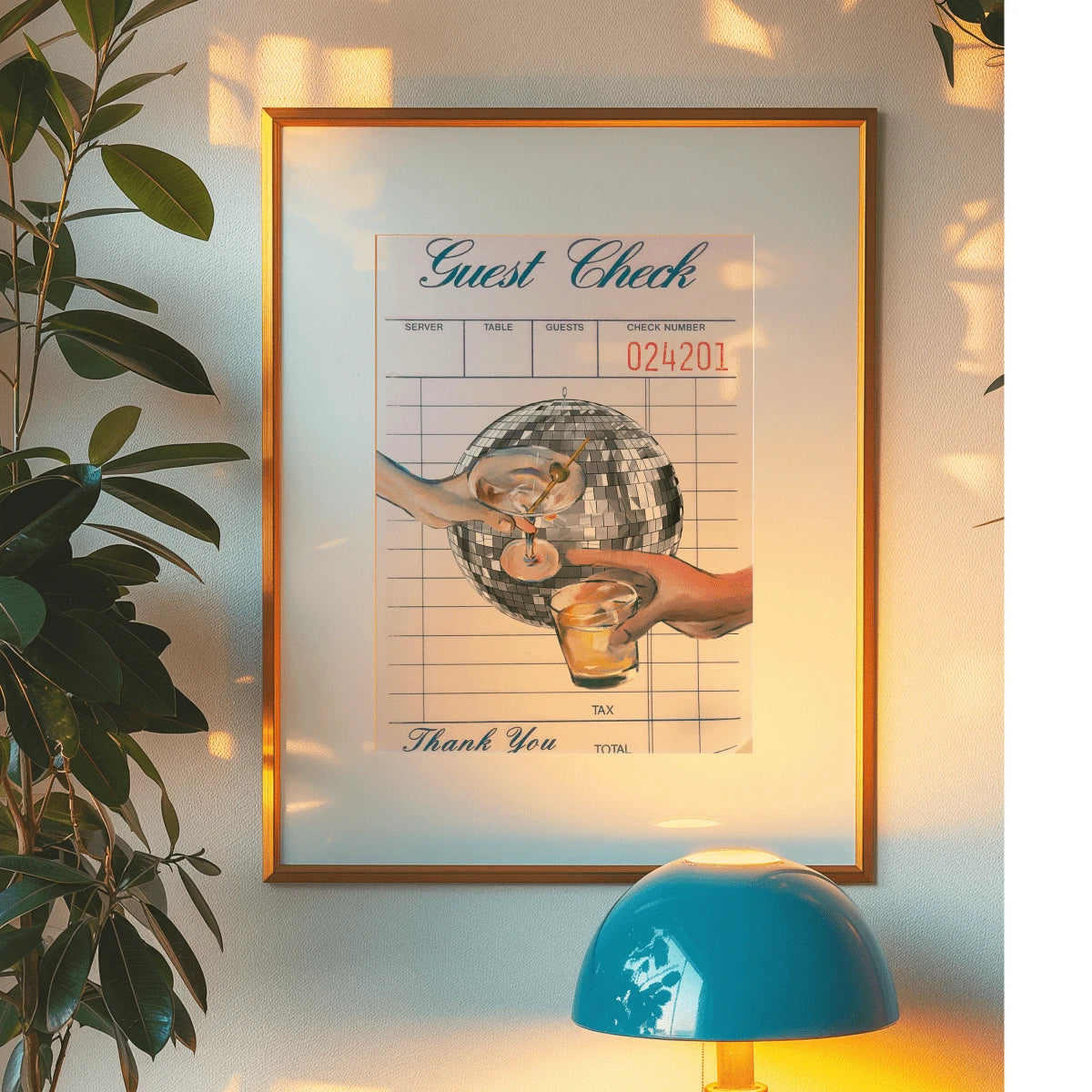 Retro cocktail canvas art in a gold frame beside houseplants