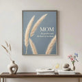 Framed Mom quote botanical wall art above a console with books and pale neutral decor