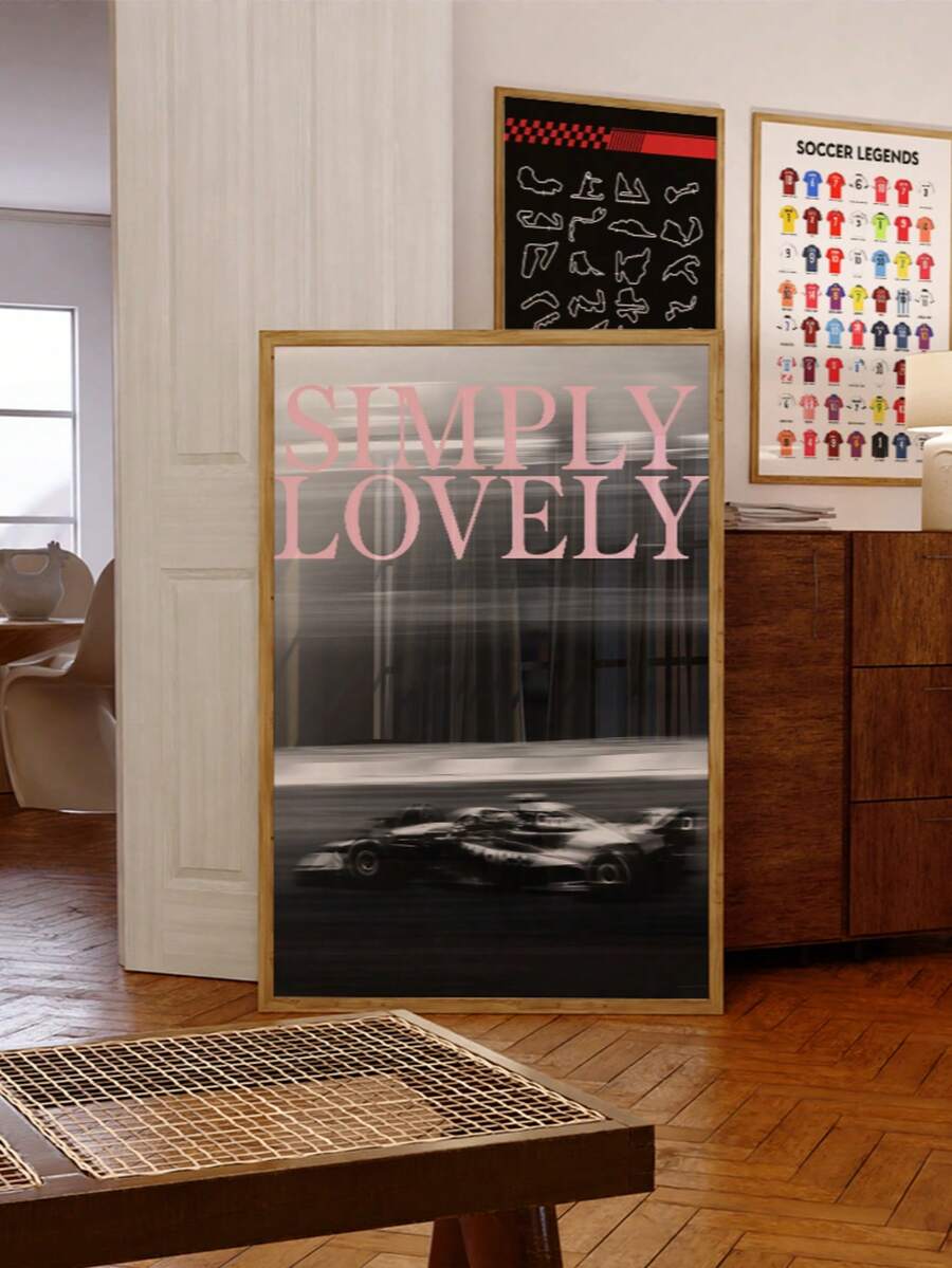 Wood-framed racing car print with pink typography styled beside a soccer poster in a warm room