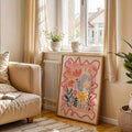 Pink folk-art wildflower canvas leaning by a bright living-room window