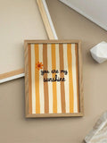 Close view of orange flower and black quote on retro yellow striped poster