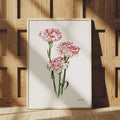 Close view of carnation botanical artwork in a light wood frame