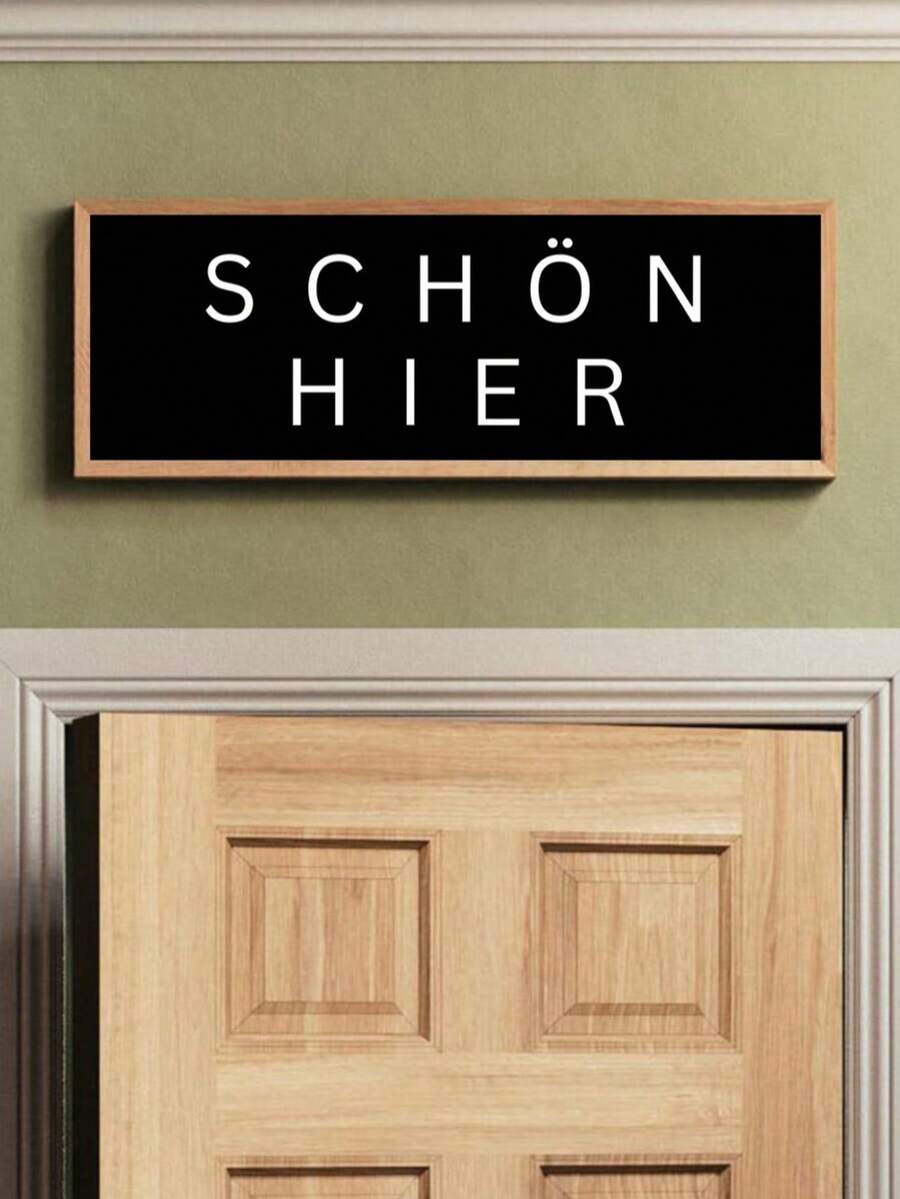 SCHÖN HIER poster with black background white lettering and wood frame