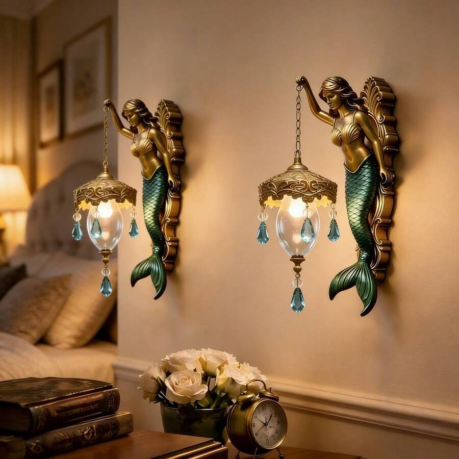 Pair of vintage mermaid wall lamps with warm yellow glow on beige wall.