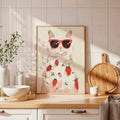Framed cat with red sunglasses and strawberry print poster on kitchen counter