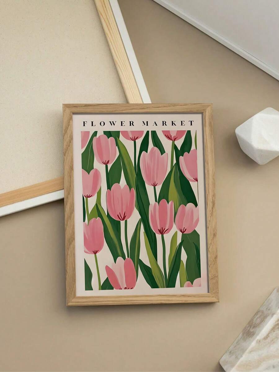 Natural wood framed pink tulip print arranged in a beige flat lay